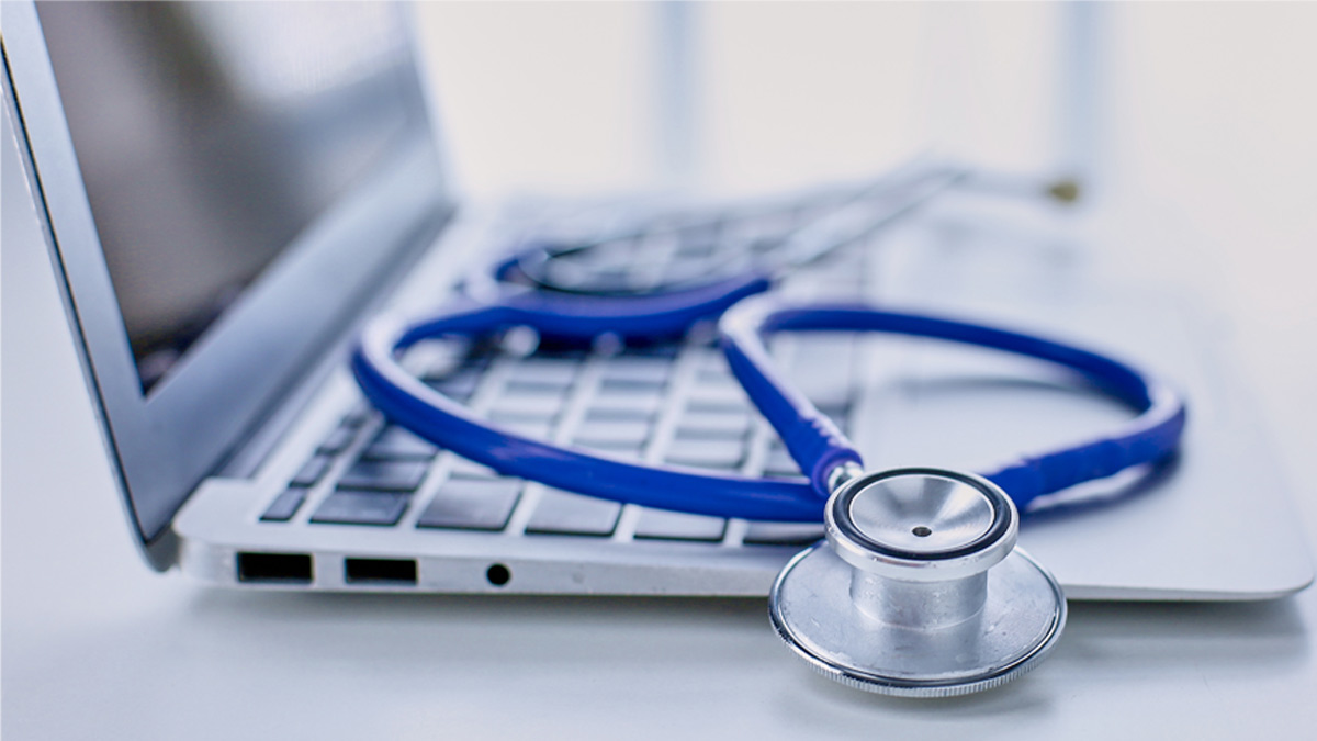 Stethoscope lying on a laptop keyboard in a concept of online medicine or troubleshooting the computer viewed low angle with copy space